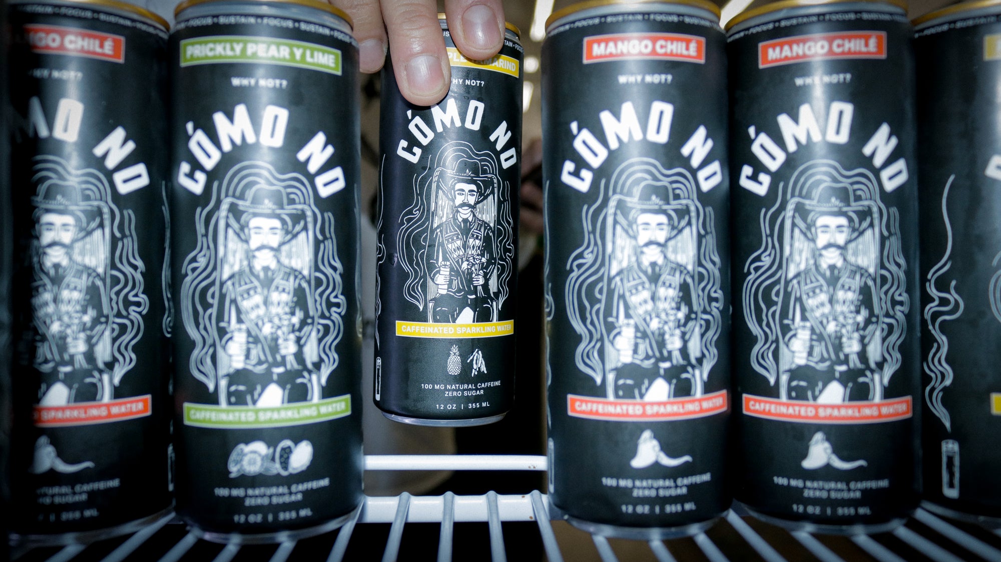 12 Pack Mixed Flavors Como No energy drink cans in black with distinctive white logo design lined up in refrigerator